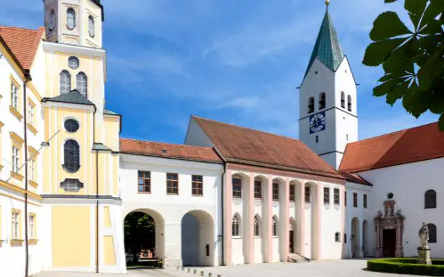 Freising Cathedral in the afternoon featuring white washed walls and blue sky